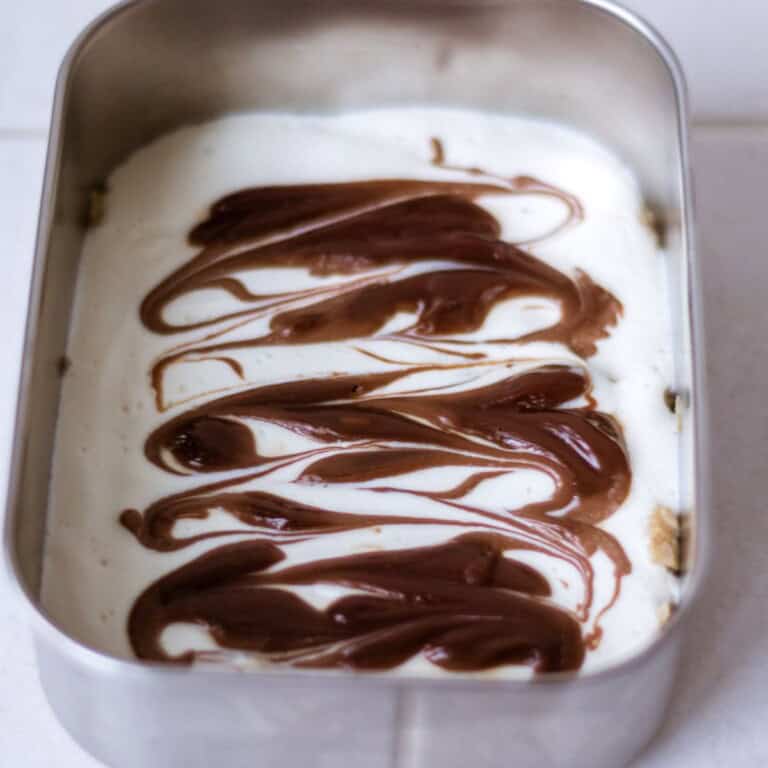 Semi-sweet chocolate and cream layered in a dessert dish for a homemade chocolate mousse recipe.