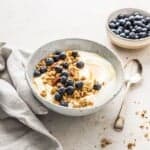 Fresh blueberry yogurt parfait with granola and honey, served in a rustic bowl. Perfect for a healthy breakfast or snack, featuring fresh blueberries, crunchy granola, and creamy yogurt.