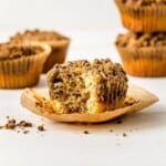 Butter and crumble streusel muffin with crumb topping, half-eaten muffin on parchment paper, fresh bakery muffin with streusel crumb topping, delicious homemade crumb muffin, relevance.