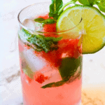Refreshing alcohol-free virgin strawberry mojito with fresh strawberries, lime slices, mint leaves, and ice in a clear glass. Perfect for summer drinks and healthy beverage options.