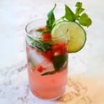 Fresh homemade strawberry mojito with mint, lime, and ice in a clear glass, perfect for summer drinks. Featuring vibrant red strawberries, fresh green mint, and slices of lime for a refreshing beverage.