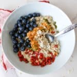 Blueberries, oatmeal, chia seeds, goji berries, pumpkin seeds, healthy breakfast bowl with oatmeal and fresh berries, nutritious vegan breakfast options.
