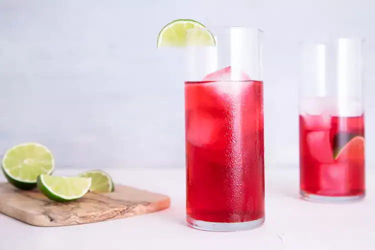 Cape Cod cocktail served in a highball glass with ice and a slice of lime.