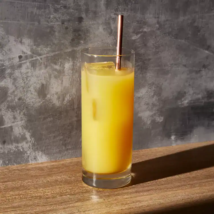 Orange juice and vodka screwdriver in a tall glass with ice.