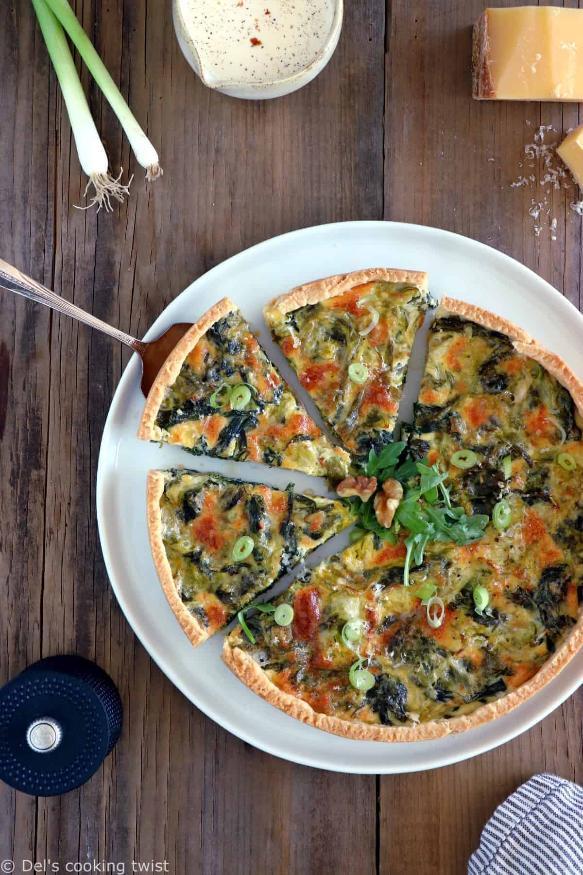 Delicious vegetable and cheese quiche with fresh herbs on a white plate, served on a rustic wooden table.