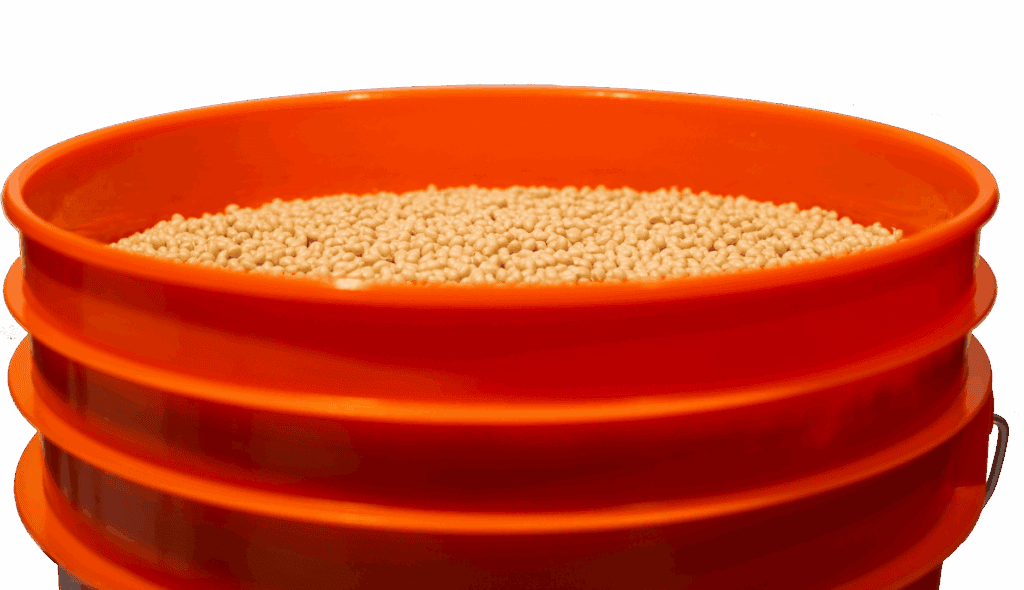 Miniature grains stored in an orange container, representing agricultural or food product storage.