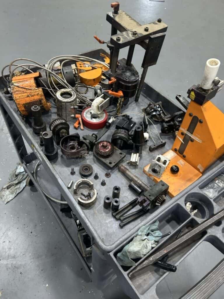 Disassembled mechanical parts and tools for industrial machinery maintenance.