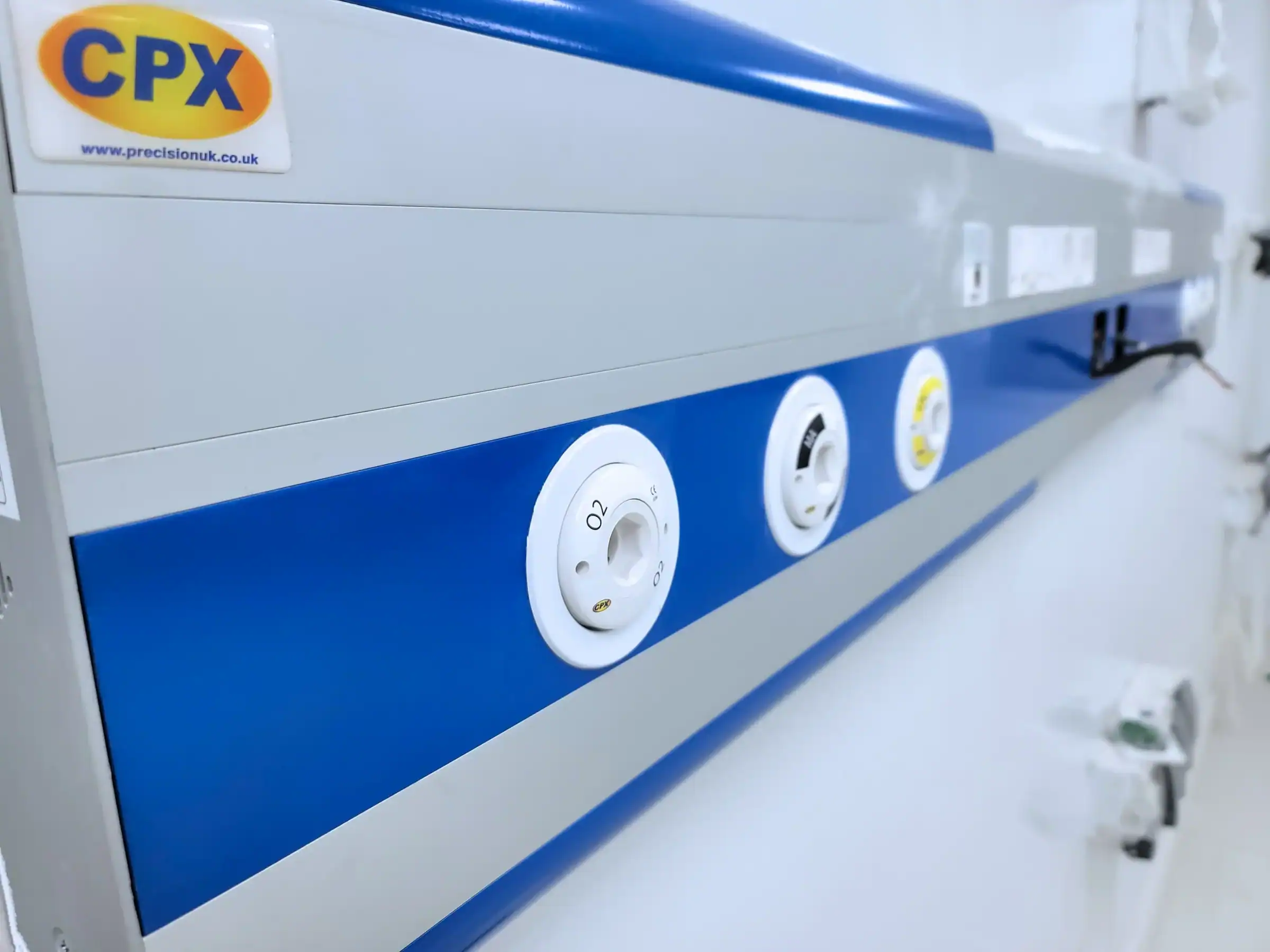 CPX Bedhead Unit with blue trim mounted on wall in hospital ward