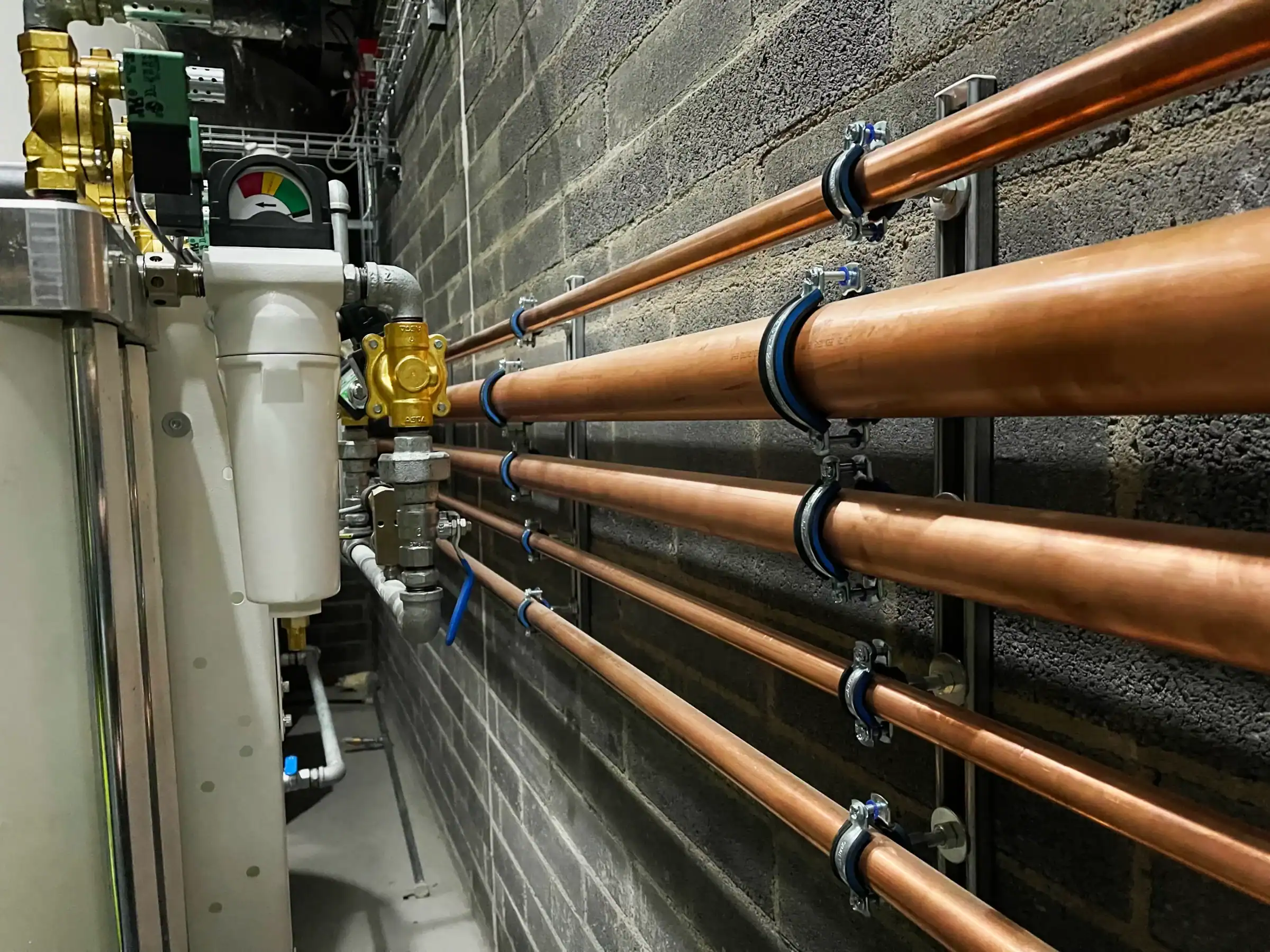 Medical Copper Pipeline running horizontally along wall in hospital plant room
