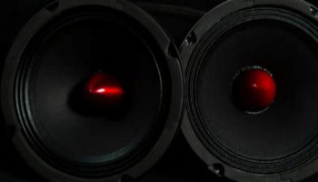 Speakers with red cones and black surrounds, showcasing premium audio equipment.