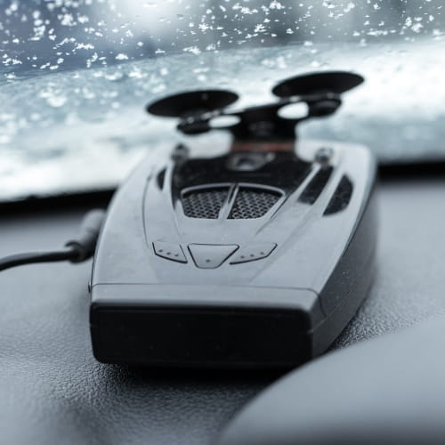 Car dashboard device mounted on windshield with snow outside.