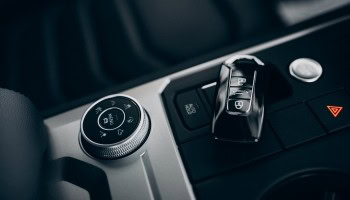 Modern car interior with gear shift and control panel, highlighting automotive styling upgrades.