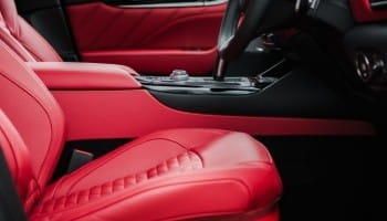 Red leather car interior with custom seats and sleek dashboard.