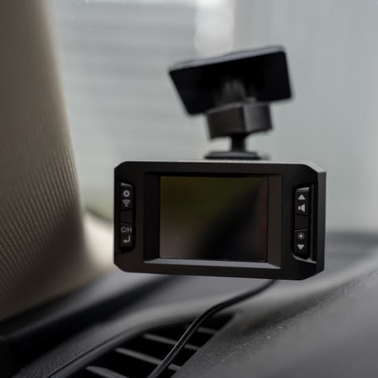 Dashboard camera mounted on car dashboard for recording trips.