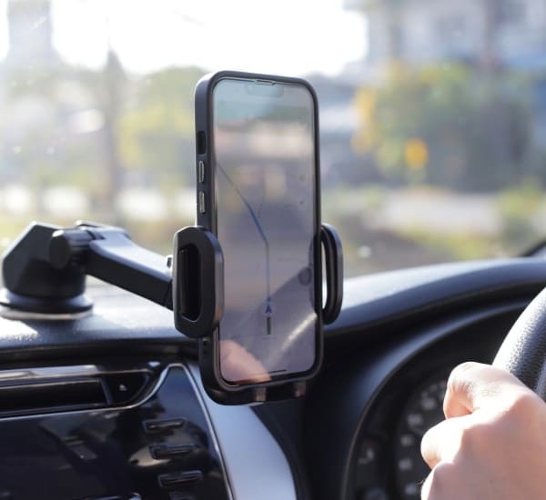 Cell phone holder with signal booster on car dashboard.