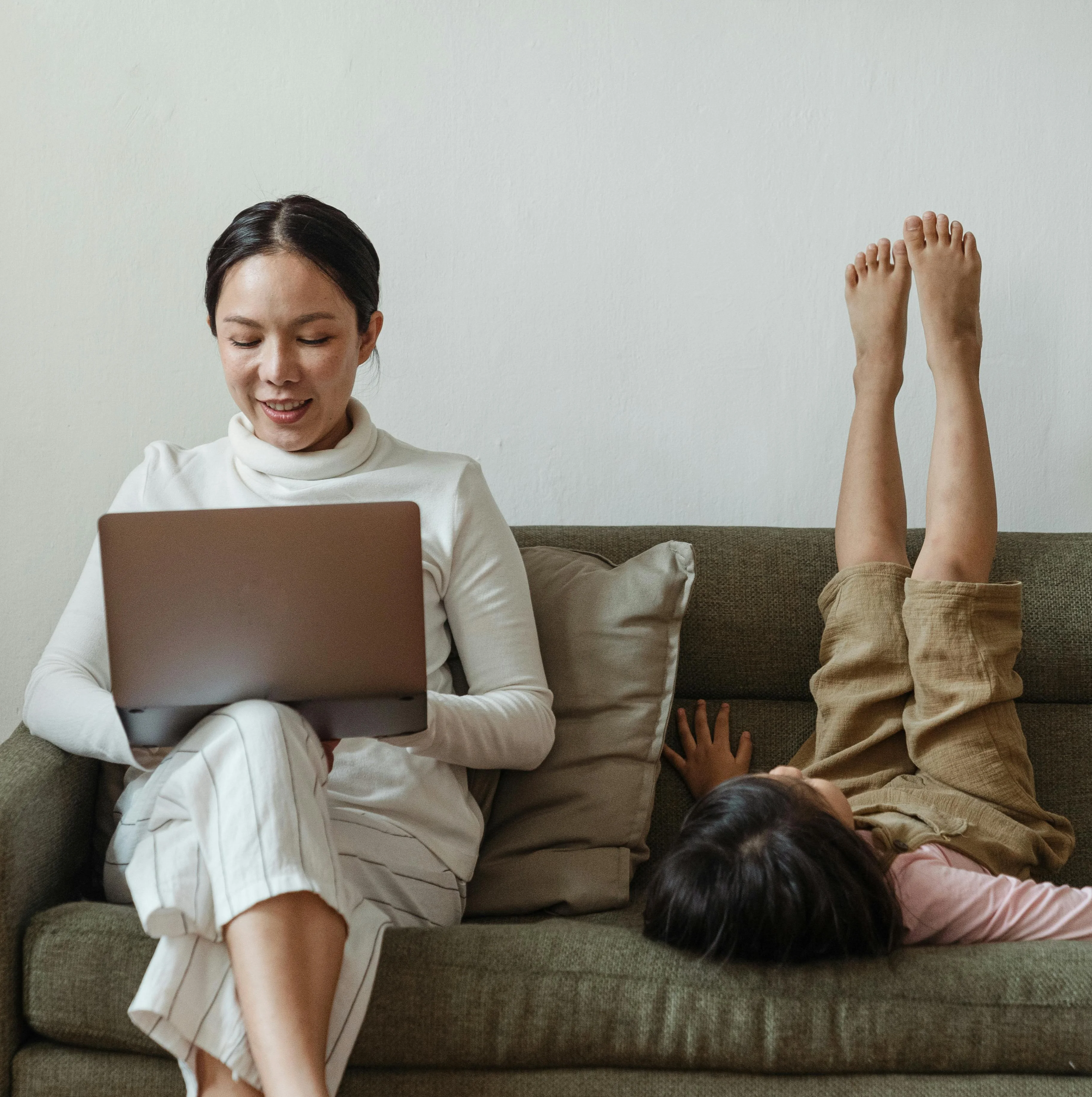 cheerful mother with laptop and child