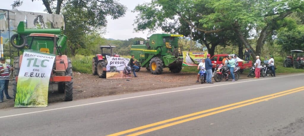 Protesta en Campoalegre con maquinaria agrícola y manifestantes en la vía, en respuesta a bloqueos y demandas de los arroceros en la región.