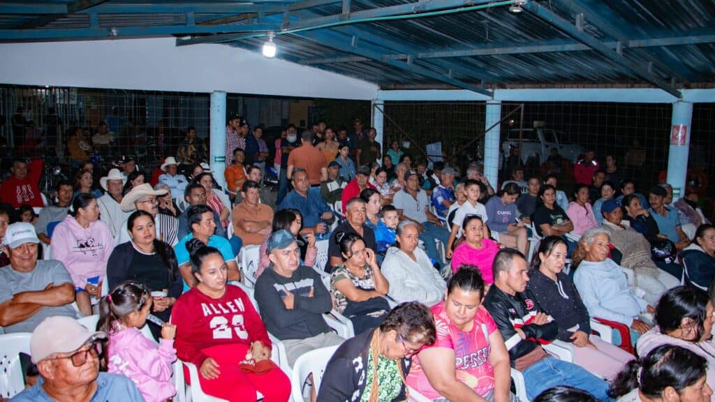 1. Personas asistiendo a un evento comunitario en Huila, Colombia, en un espacio abierto cubierto, mostrando participación y cohesión social en un entorno rural.