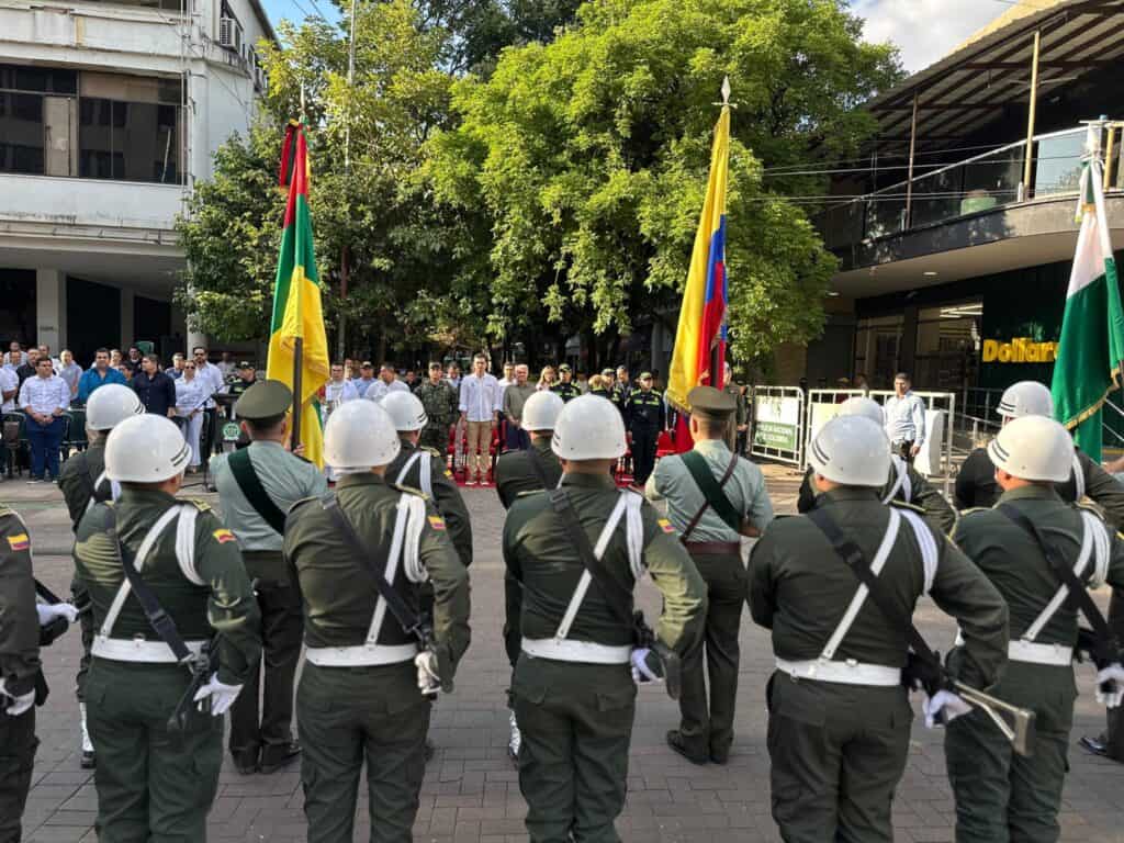 Soldados del Ejército colombiano durante una ceremonia oficial en Huila, en una plaza pública, con banderas de Colombia y diferentes países, en un evento formal con presencia de autoridades y público asistente.