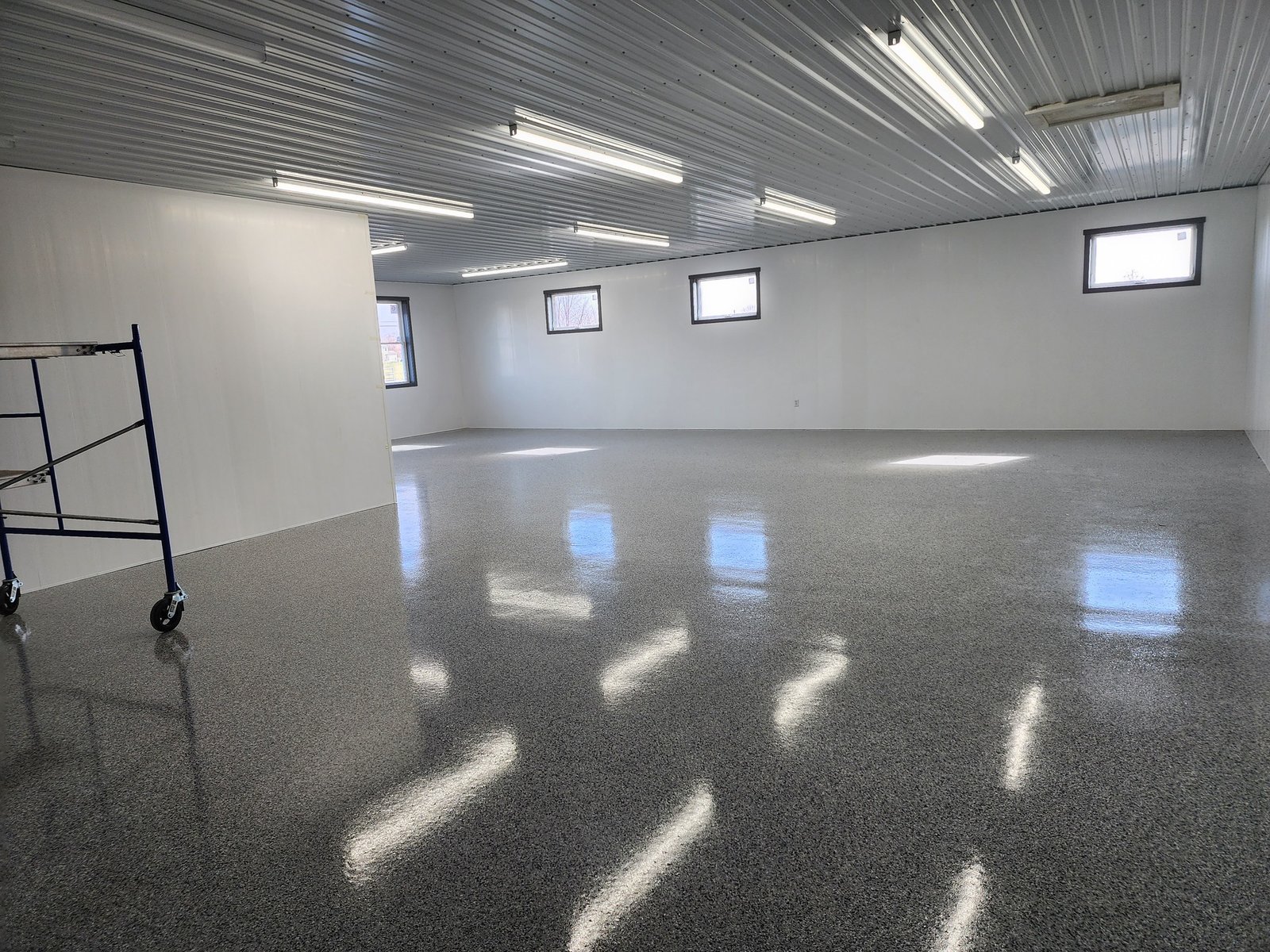 This image shows a clean and bright room that highlights J&P Coatings’ skill in finishing basement floors and patios.