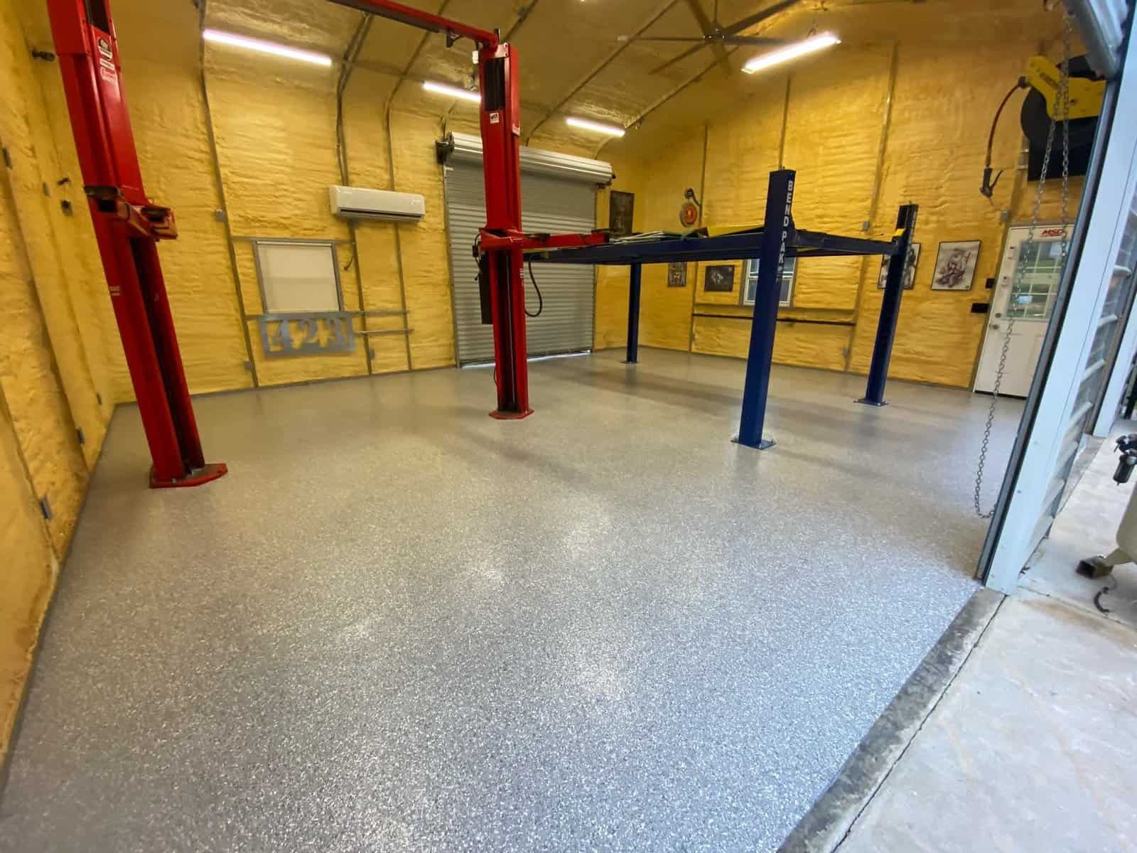 A garage with a fresh, smooth epoxy floor by J&P Coatings that looks safe and ready for use.