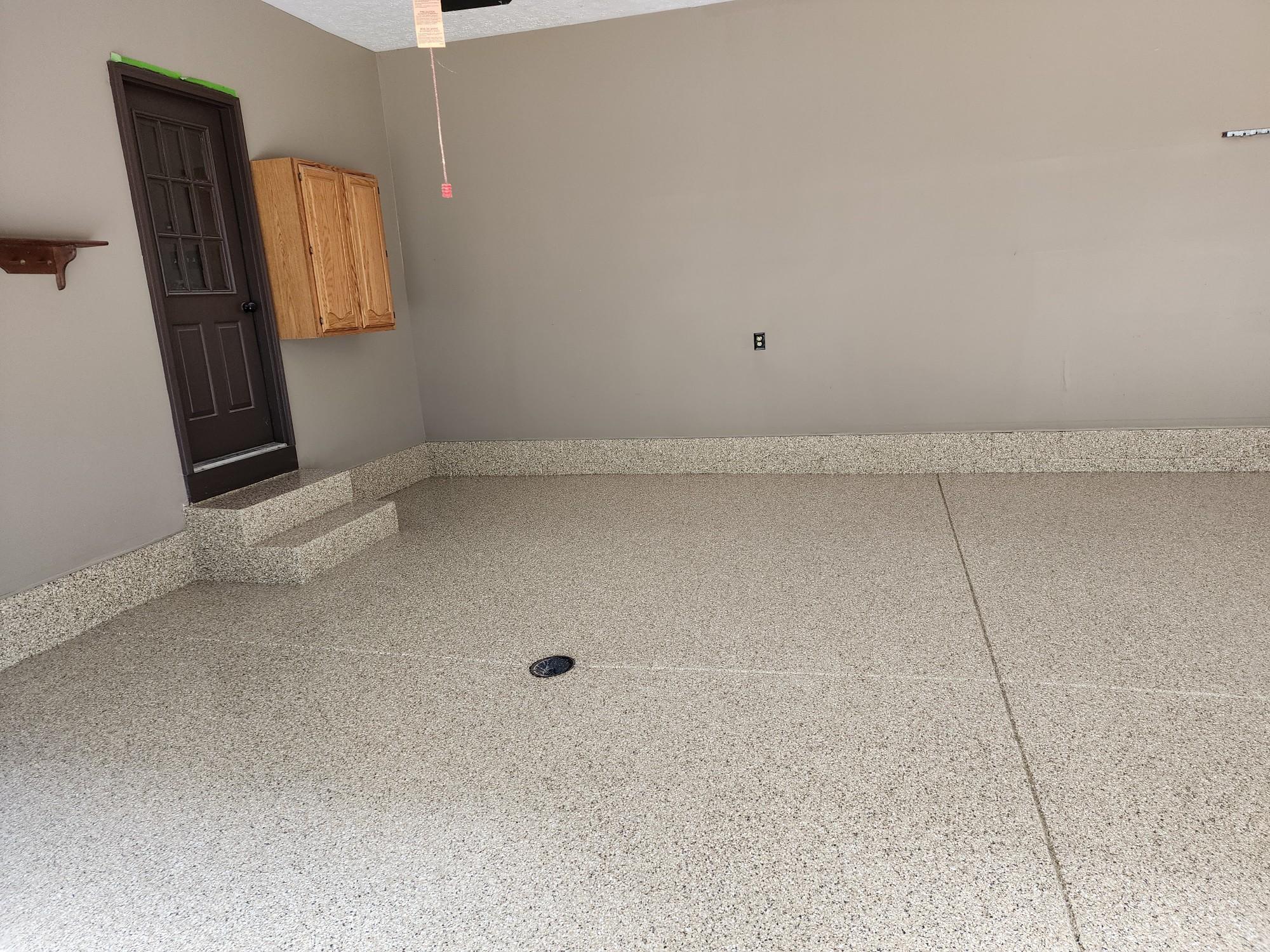 A freshly finished garage shows J&P Coatings’ smooth epoxy flooring. The space looks neat and ready to use.