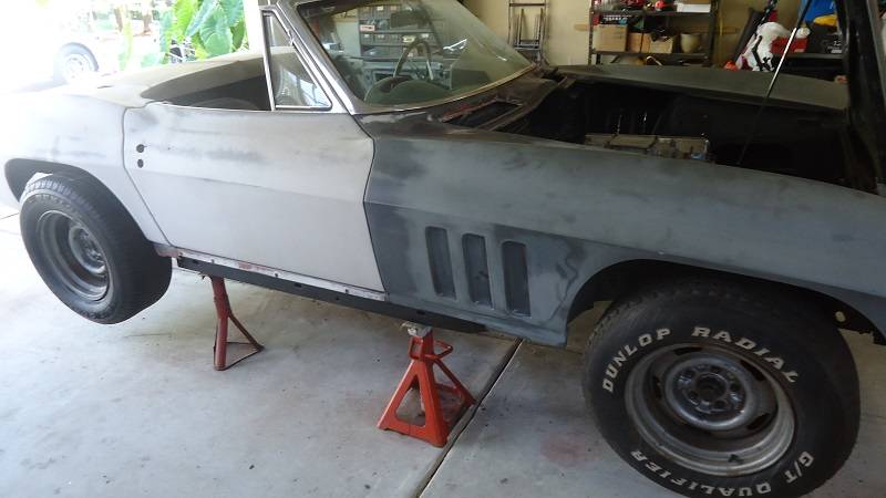 this is a picture of a classic car restomod project car on a jack stand used for winter storage