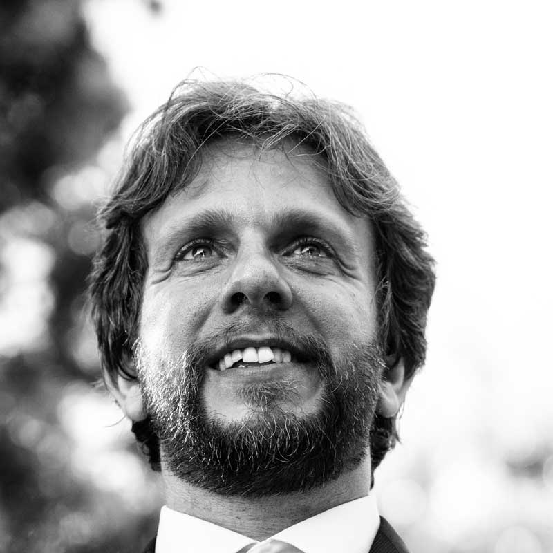 a black and white photo of a man wearing a suit and tie