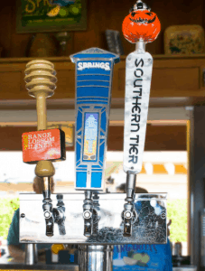 Orange Blossom Pilsner and Southern Tier tap handles at Disney Springs bar, radiating Oktoberfest excitement for park guests.