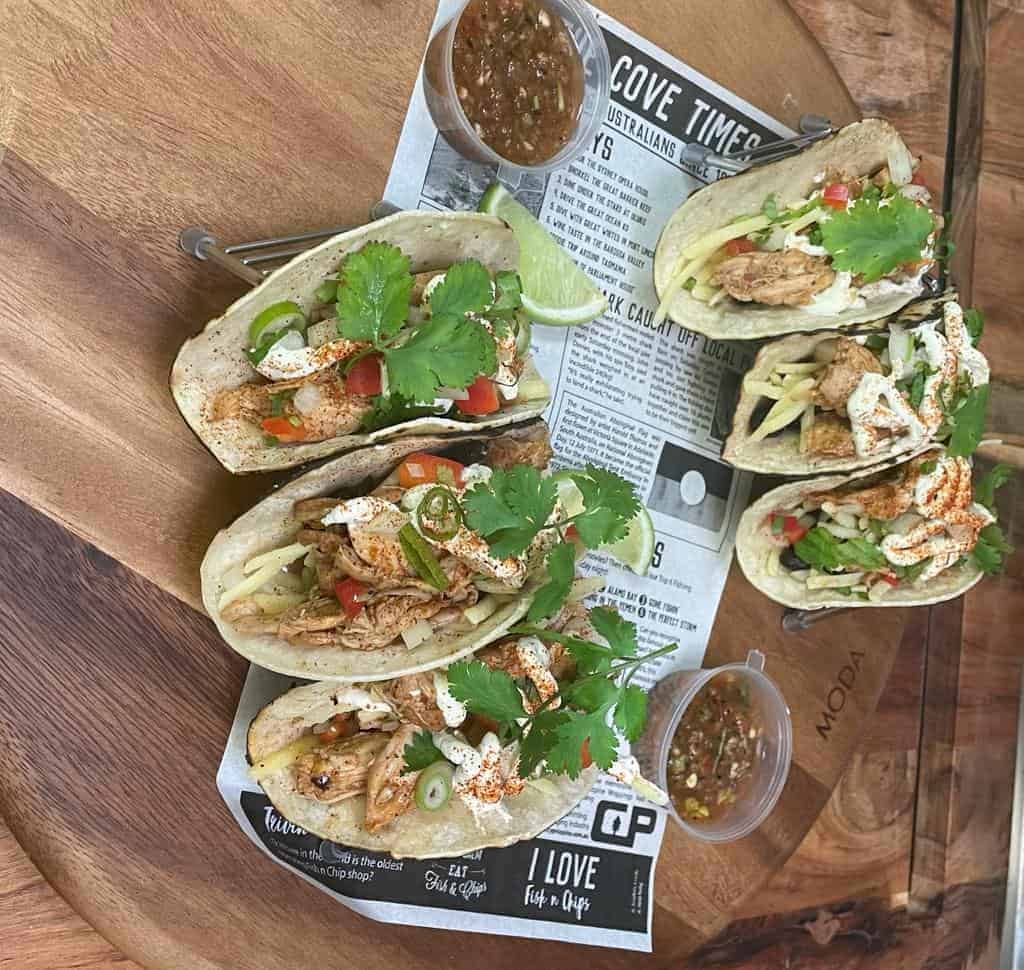 Chicken tacos with fresh cilantro, chopped vegetables, and flavorful salsa.