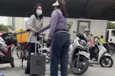 バス待ちしている若い女性の荷物を蹴る露天商の女性