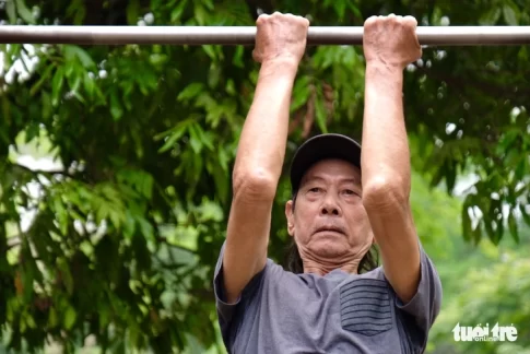 鉄棒で運動する高齢者