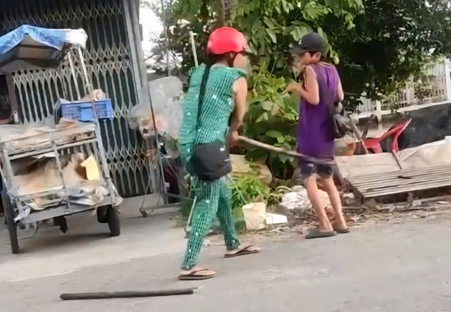 甥を木の棒で叩く女性