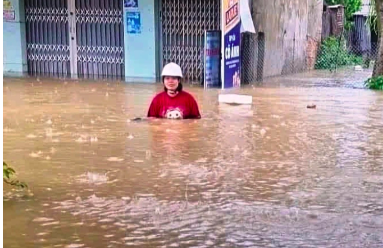 冠水したダナン市内の道路を歩く女性