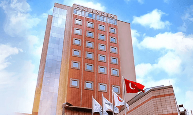 Acibadem Hospitals Group building with Turkish flags, modern healthcare facility in Turkey.