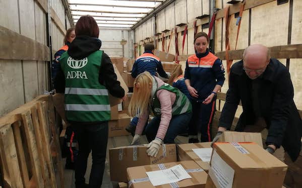 1. Mitarbeitende bei Advent-Verlag packen Pakete in einem Logistikzentrum für Versand und Kundenbestellungen.
