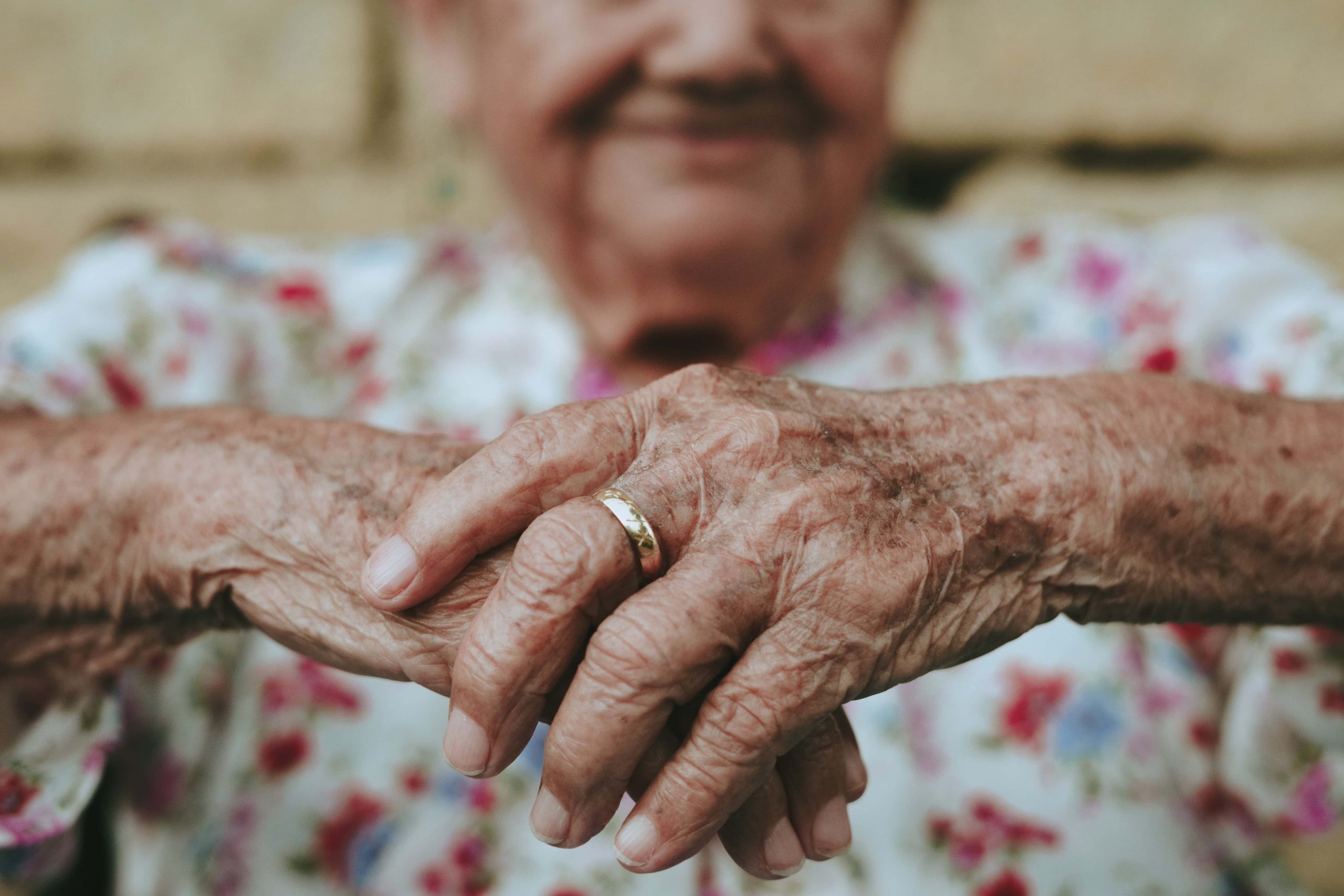 Ältere Hände mit Ringen, Nahaufnahme, symbolisiert Fürsorge, Liebe und Zusammenhalt bei älteren Menschen, ideal für Senioren- und Pflegethemen.