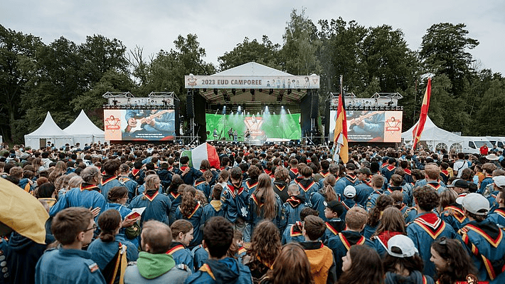 1. Großes Publikum bei der Advent-Verlag Veranstaltung auf dem EUD Camporee, mit Bühne, Musik und Scouts in Uniformen, Outdoor-Event, Familienfeiern, deutsches Event, Gemeinschaft.