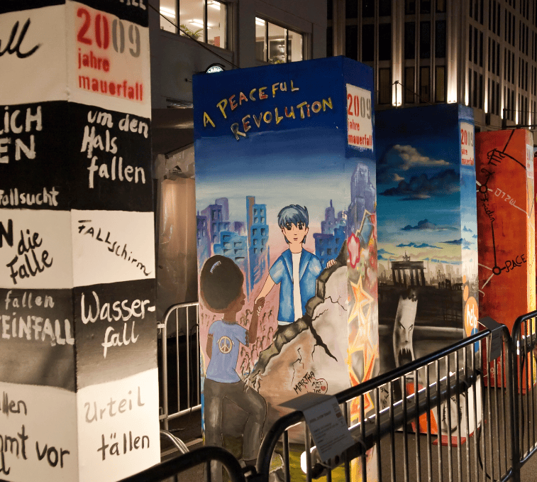 Zerbrochene Wandmalerei mit Friedenssymbolen und urbaner Szenerie, Kunst im öffentlichen Raum, kreative Street Art, gesellschaftskritische Graffiti, symbolischer Protest, nachhaltige Kunst, urbanes Kunstprojekt, Thema Frieden und Klimawandel.