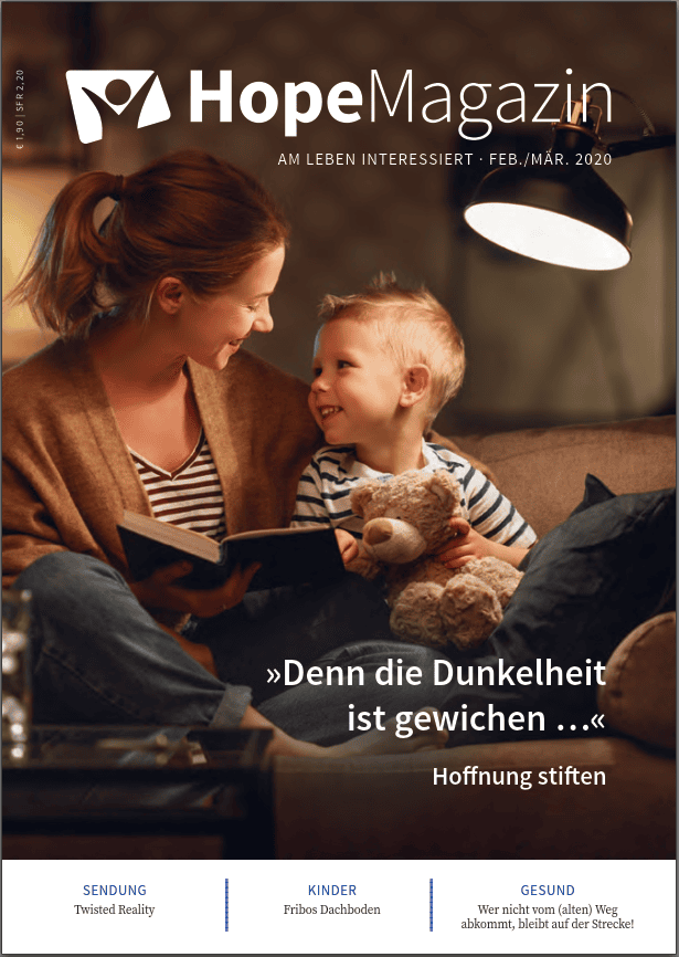 Mit Kinderbuch und Mama beim Vorlesen, Kerzenlicht schafft eine gemütliche Atmosphäre.