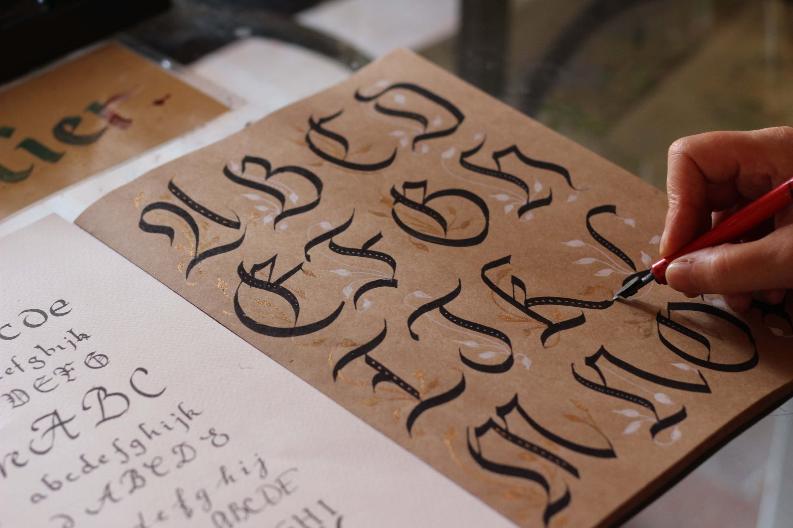 Handgezeichnete kalligraphische Buchstaben für Weihnachts- oder Adventskarten, hochwertiges Schreibhandwerk, kreative Gestaltung mit Tinte, perfektes Schreiben für festliche Grüße bei Advent-Verlag.