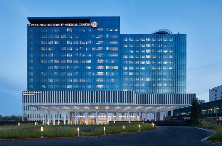 1. Modernes Rautaden-Gebäude des Loma Linda University Medical Center in blauer Abendstimmung, Fokus auf Architektur und medizinische Innovationen.