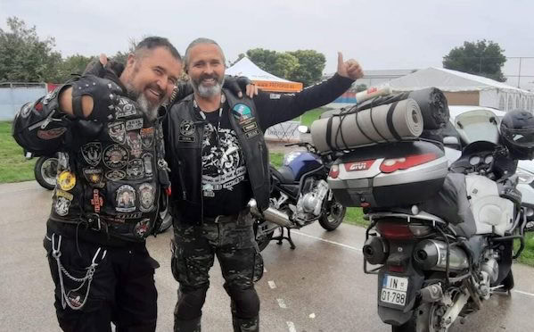 Abenteuerliche Motorradreise mit zwei Biker-Fahrern, vollgepackt mit Ausrüstung, unterwegs auf nasser Straße, bei Regenwetter, bei einer Motorradtour.