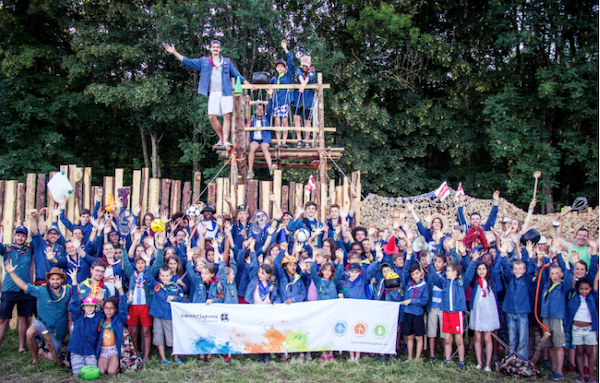 Abenteuerliches Gruppenfoto von Kindern und Betreuern beim Jugendcamp, umgeben von Natur, beim Klettern und Spielen. Perfekt für kirchliche Jugendveranstaltungen, Lager und Bildungsreisen.