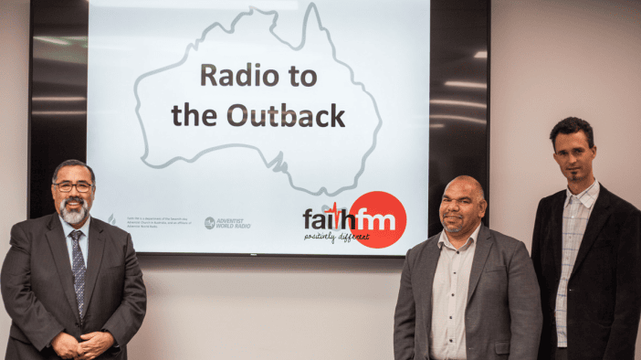 Radio to Outback: Australisches Abenteuer und Medien, Menschen im professionellen Umfeld, Präsentation in einem Konferenzraum, australischer Kontinent auf großem Bildschirm, authentisches Bild für evangelische Medien und Outback-Themen.
