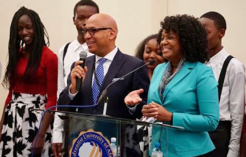 Vielfältige Gruppe bei öffentlicher Veranstaltung, mit Rede und Publikum, die den Einsatz von Bildmaterial für Veranstaltungs- und Bildungspolitik zeigt.