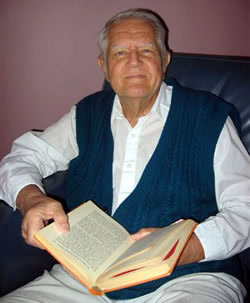 Ein älterer Mann liest ein Buch, sitzt entspannt im Sessel, in einem gemütlichen Zuhause, hochwertige Literatur, Lesegenuss, ruhige Atmosphäre, perfektes Ambiente für Bücherliebhaber.