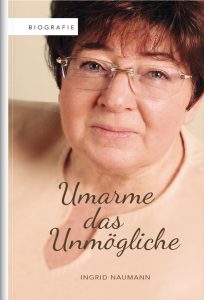 Gerührtes Portrait einer älteren Frau mit Brille, Buchcover für "Umarme das Unmögliche" von Ingrid Naumann, emotionale Darstellung, literarische Biografie, Inspiration für persönliche Entwicklung und Überwindung.