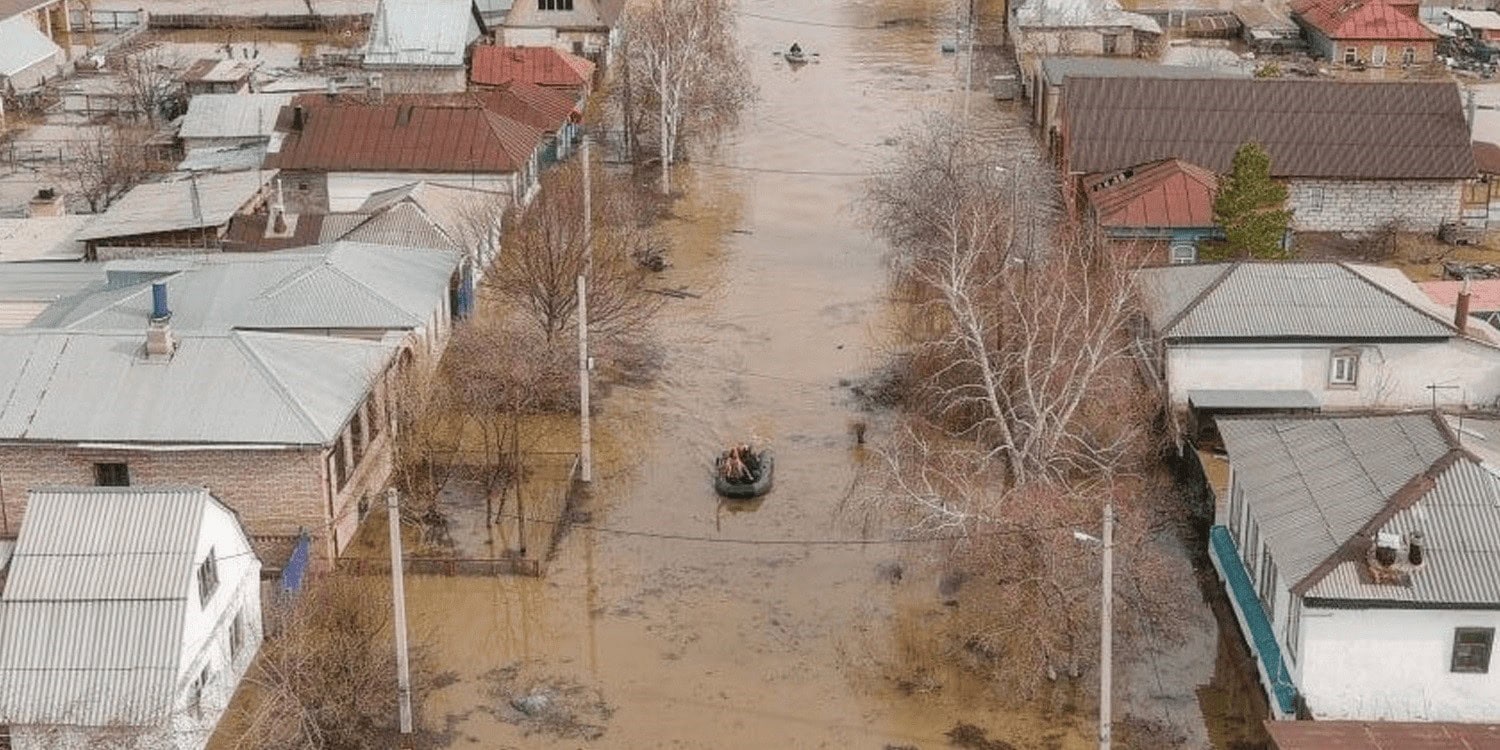 überschwemmtes Wohngebiet mit Wasser auf der Straße, beschädigte Häuser und treibende Äste, nach Hochwasser, Katastrophe, Naturkatastrophe, Essentielle Bilder für Hochwasserwarnung und Katastrophenschutz.