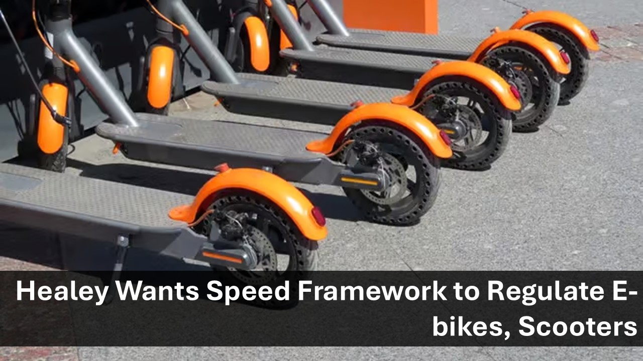 Row of orange electric scooters lined up in a parking area with a news headline overlay: 'Healey Wants Speed Framework to Regulate E-bikes, Scooters'